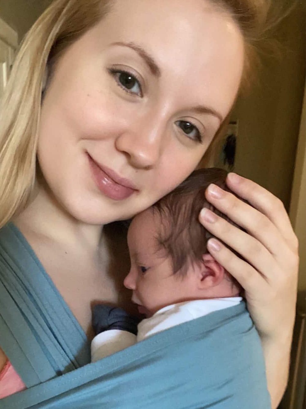 Mother and newborn son babywearing in postpartum